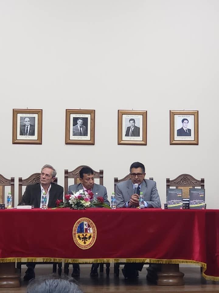 Asamblea con autoridades en mesa oficial con escudo