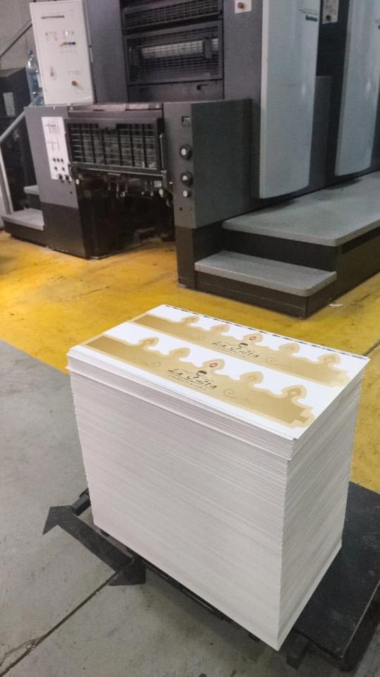 Máquina impresora offset en taller con papel impreso